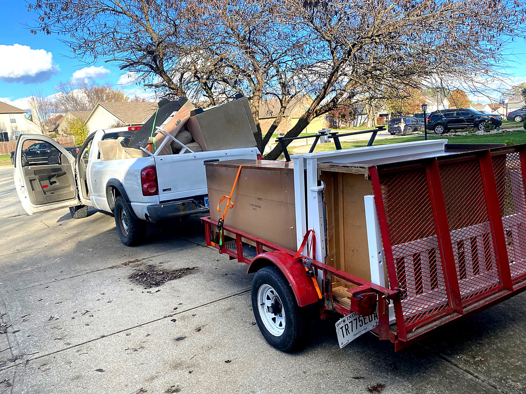 Pickup truck and loaded trailer parked at an Indianapolis home for a junk removal job